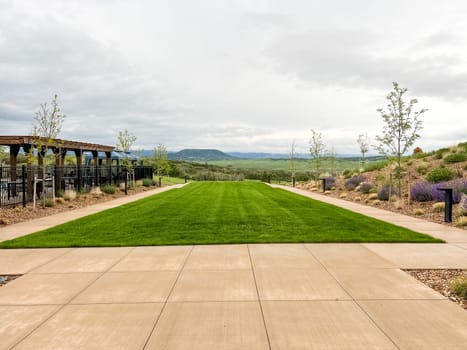 Castle Rock, Colorado, USA-June 11, 2023-Wide angle panoramic view of the Montaine community in Castle Rock Colorado showcasing a beautifully designed landscape with walking paths native plants stone benches and a clubhouse in the background The open green spaces and modern amenities highlight the communitys outdoor living appeal