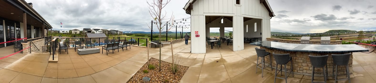 Castle Rock, Colorado, USA-June 11, 2023-Wide angle panoramic view of the Montaine community in Castle Rock Colorado showcasing a beautifully designed landscape with walking paths native plants stone benches and a clubhouse in the background The open green spaces and modern amenities highlight the communitys outdoor living appeal