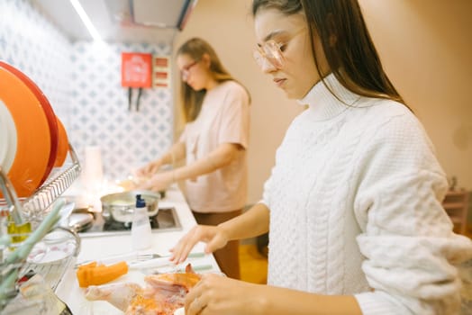 Two women joyfully cook in a bright kitchen, showcasing the beauty of collaboration in their culinary work