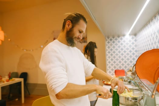 A man is happily cooking in a stylish kitchen, crafting joyful culinary memories that will last for a lifetime