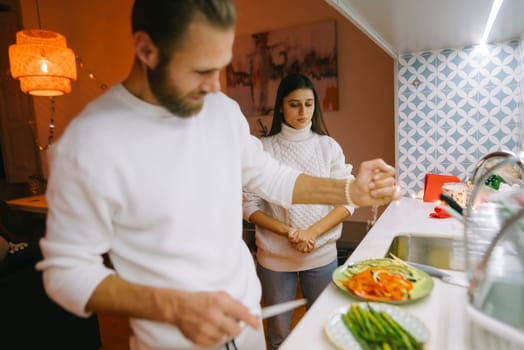 A couple enjoys a delightful and cozy cooking moment together in a beautifully designed and stylish kitchen