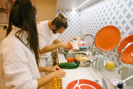 A couple shares the joy of cooking together in their kitchen, demonstrating teamwork and preparing delicious meals