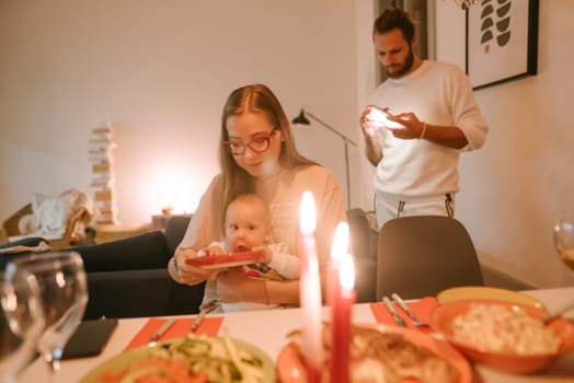 A cozy family gathering has a joyful baby, flickering candles, and delicious food to savor and enjoy