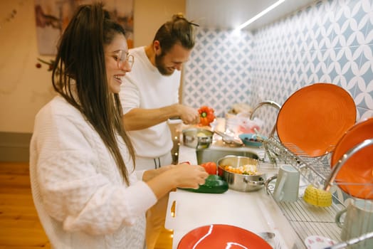 A joyful couple prepares delicious and mouthwatering food together in their modern kitchen, enjoying quality time