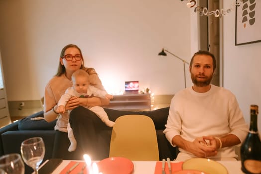 A delightful and cozy family dinner setting showcasing a woman, a man, and their cherished baby enjoying time together