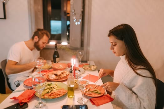 A lovely couple cherishes a romantic candlelit dinner filled with delicious pasta, fine wine, and an inviting cozy aura