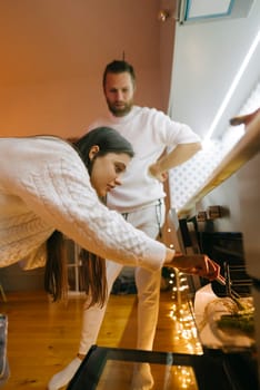 A cozy indoor setting featuring two individuals engaged in a creative activity with warmth and focus.