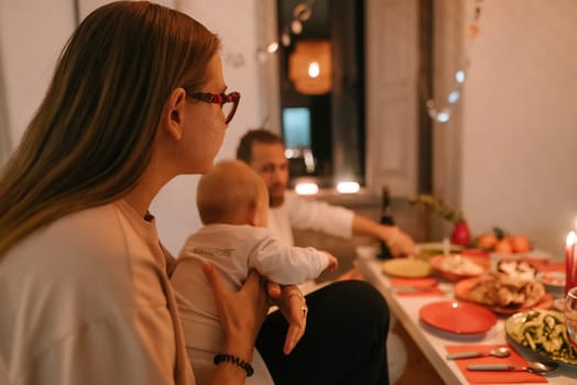 A warm and inviting family dinner setting that features a lovely baby, deliciously arranged food, and a cozy ambiance