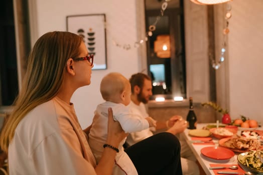 A warm and inviting family dinner scene featuring loving parents and their adorable baby in a cozy setting