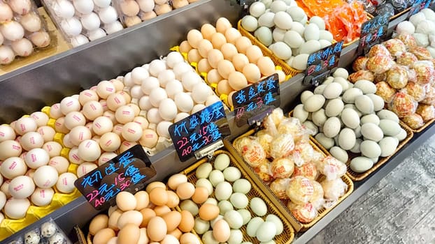 Hong Kong, China - April 09, 2024: Fresh eggs displayed in a vibrant market in Hong Kong, showcasing various types and colors available for shoppers.