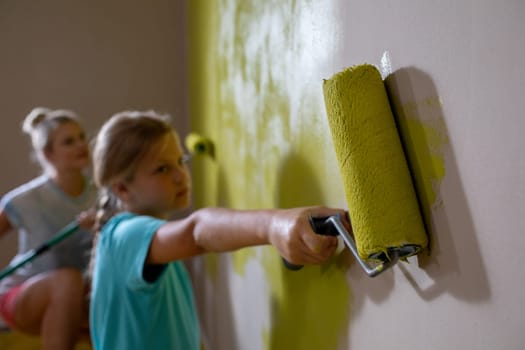 Two kids joyfully paint a wall bright yellow, capturing the essence of creativity and funfilled expression