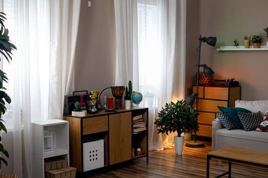 A stylish modern living room designed with ample natural light, vibrant plants, and sleek, contemporary decor