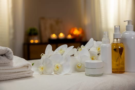 A serene spa scene with arranged towels, fragrant oils, and elegant flowers for relaxation and rejuvenation