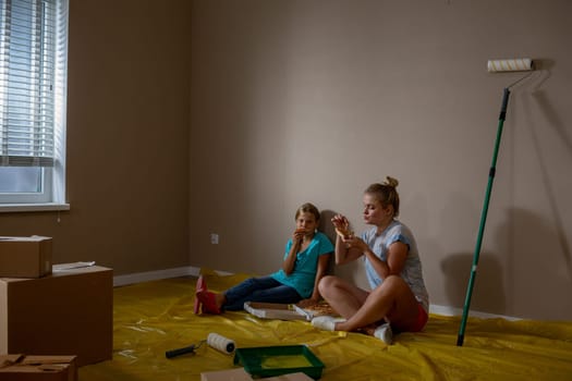 Two women are enjoying a variety of delicious snacks while they take a muchneeded break from painting their new home