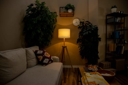 A tranquil and serene living room that showcases a soft and inviting couch, ambient lighting, and vibrant lush greenery