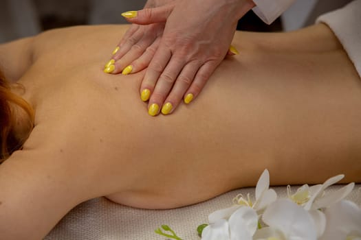 Experience a soothing massage session enhanced by bright yellow nail polish, which promotes deep relaxation