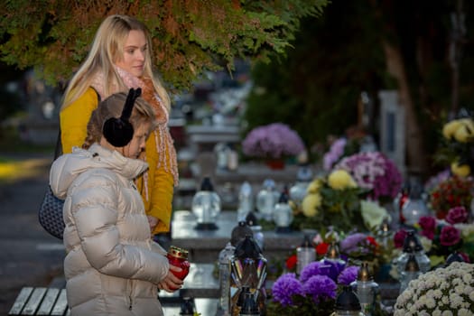 A poignant moment at a serene cemetery, adorned with vibrant flowers and candles, symbolizing love and remembrance