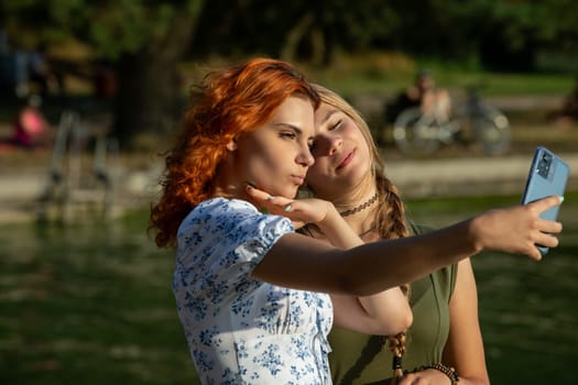 Two stylish women beautifully capture a joyful moment by a serene pond, showcasing their deep friendship