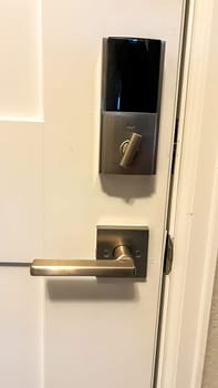 Castle Rock, Colorado, USA-September 14, 2023-A modern electronic keypad door lock installed on a white interior door The lock features a sleek metallic finish with a lever-style handle and a digital keypad for secure access The door appears to be part of a residential or commercial property