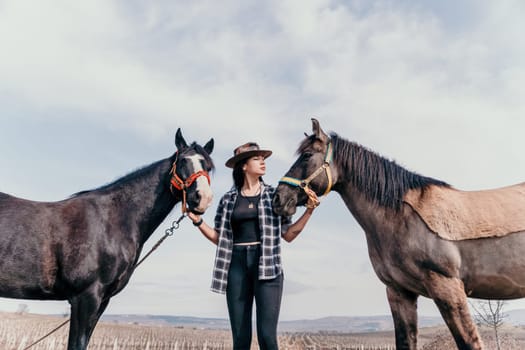 Cute happy young woman with horse. Rider female drives her horse in nature on evening sunset light background. Concept of outdoor riding, sports and recreation.