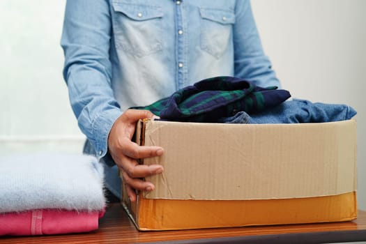 Clothes donations in cardboard box for volunteer.