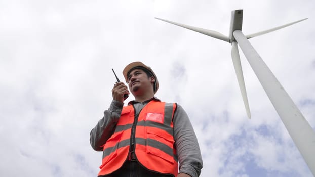 Engineer working on a wind turbine with the sky background. Progressive ideal for the future production of renewable, sustainable energy. Energy generation from wind turbine.