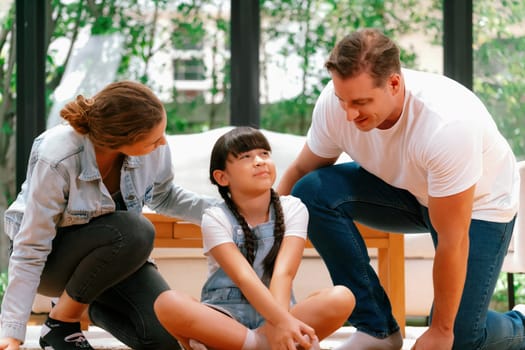 Parents comforting their daughter with loving embrace, helping her feel secure and protected as she rest her head on their shoulder. Happy family love and child care support concept. Synchronos