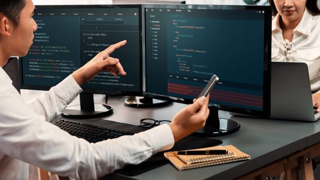 Software development team working together in office, coding script display on computer monitor. Programmer and software engineer working in tech developer company. Trailblazing