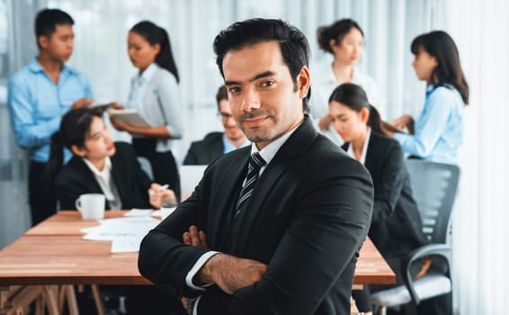 Portrait of happy businessman looking at camera with motion blur background of business people movement in dynamic business meeting. Habiliment