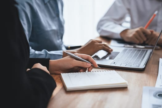 Diverse business people work together, discuss in corporate office. Professional teamwork discussing and pointing at laptop. Modern multicultural office worker. Concord