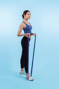 Vigorous energetic woman in sportswear portrait stretching resistance sport band. Young athletic asian woman strength and endurance training session workout routine concept on isolated background.