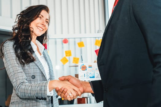 Business people handshake in corporate office showing professional agreement on a financial deal contract. Jivy