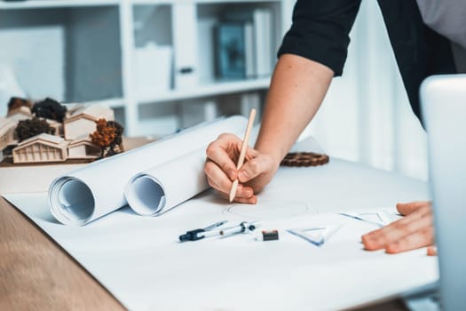 Drafting interior house design by architect designer planning home layout on blueprint paper on office desk. Architect carefully drawing home interior layout with pencil and tool. Iteration