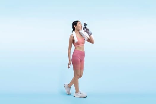 Athletic and sporty asian woman resting and drink water after intensive cardio workout training. Healthy exercising and fit body care lifestyle pursuit in studio shot isolated background. Vigorous