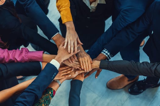 A group of diversity people putting their hands together. Showing unity teamwork and friendship. Close up top view of young business man and business woman joining as a team. Intellectual.