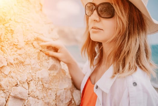 Young woman in red bikini on Beach. Blonde in sunglasses on pebble beach enjoying sun. Happy lady in one piece red swimsuit relaxing and sunbathing by turquoise sea ocean on hot summer day. Close up,