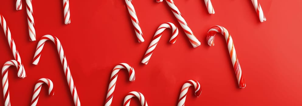 Banner Christmas background with Xmas candy canes. Top view, flat lay. Christmas candy cane on red background. Copy space for text. Christmas design