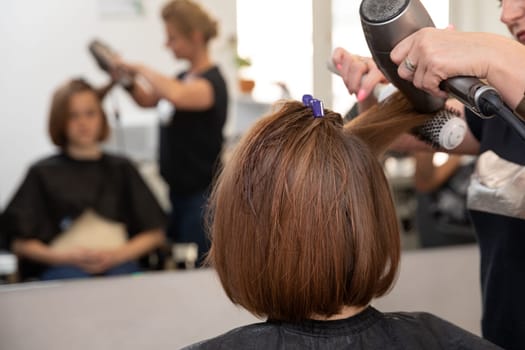 A skilled professional hairstylist performing a refreshing blowdry at a stylish, modern salon setting