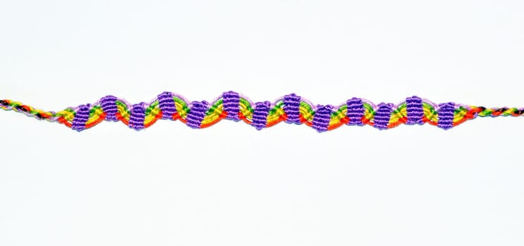 Multicolored woven DIY friendship bracelets handmade of embroidery bright thread with knots isolated on white background