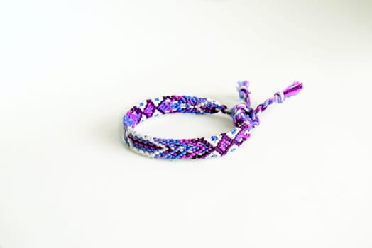 Multicolored woven DIY friendship bracelets handmade of embroidery bright thread with knots isolated on white background