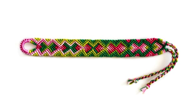 Multicolored woven DIY friendship bracelets handmade of embroidery bright thread with knots isolated on white background