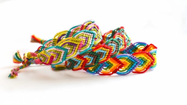 Multicolored woven DIY friendship bracelets handmade of embroidery bright thread with knots isolated on white background