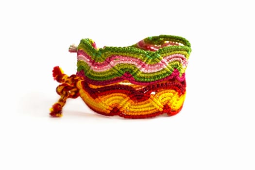 Multicolored woven DIY friendship bracelets handmade of embroidery bright thread with knots isolated on white background