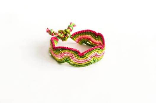 Multicolored woven DIY friendship bracelets handmade of embroidery bright thread with knots isolated on white background