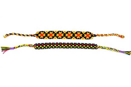 Multicolored woven DIY friendship bracelets handmade of embroidery bright thread with knots isolated on white background