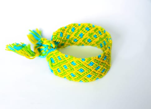 Multicolored woven DIY friendship bracelets handmade of embroidery bright thread with knots isolated on white background