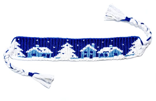 Woven friendship bracelet with Christmas alpha pattern Snowy night with houses. Handmade of thread, isolated on white background. New Year DIY gift idea