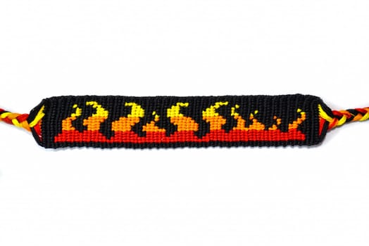 Woven DIY friendship bracelet handmade of embroidery bright thread with knots isolated on white background.