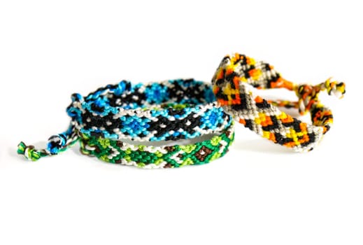 Multicolored woven DIY friendship bracelets handmade of embroidery bright thread with knots isolated on white background