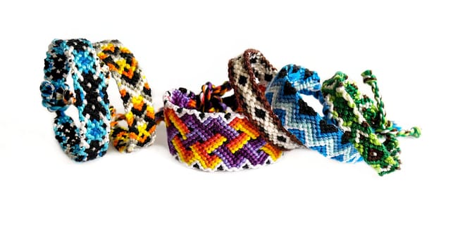 Multicolored woven DIY friendship bracelets handmade of embroidery bright thread with knots isolated on white background